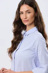 Camisa de lino celeste con cuello clásico, cierre frontal con botones y mangas tres cuartos terminadas en volados.