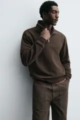 Sudadera regular fit de color marrón, con cuello alto y cierre frontal de cremallera corta, manga larga y puños y dobladillo en rib.