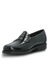 Mocasines tipo slip-on de cuero negro con acabado brillante, diseño clásico con banda frontal y suela de poliuretano con tecnología Bounce para mayor confort y absorción de impactos.