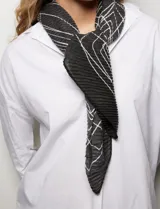 Pañuelo o pashmina cuadrado, color negro con estampado de líneas blancas que simulan costuras o puntadas. El tejido es plisado.