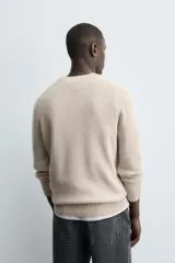 Jersey azul de punto con cuello redondo y manga larga. Tejido en mezcla de lana y acabado en rib.