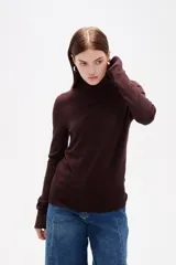 Polera de lyocell color negro, con cuello alto y ajuste al cuerpo, de manga larga.