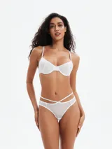 Bombacha de bikini blanca, tiro bajo, con tiras cruzadas decorativas en la parte delantera de la cintura.