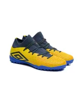 Championes de fútbol 5 Umbro modelo Ignis TF, con diseño de corte medio en tejido elástico color azul marino y cuerpo texturizado en color amarillo. Presenta suela de goma con tapones pequeños para césped sintético y logo de la marca en el lateral.