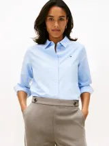 Camisa oxford Tommy Hilfiger de corte relaxed en color celeste, con cuello camisero, mangas largas y cierre frontal de botones. Presenta el logo de la marca bordado en el pecho.