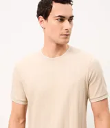 Remera de algodón peruano color beige con textura de rayas verticales, cuello redondo y mangas cortas.