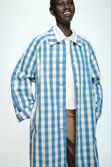 Camisa corta de popelín en color blanco, con cuello solapa decorado con abalorios joya, manga larga y cierre frontal con botones.