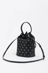 Bolso tipo bucket de nylon negro con tachas metálicas plateadas distribuidas por toda la superficie. Cuenta con cierre de cordón ajustable, asa de mano superior y correa larga para llevar al hombro o cruzado. Incluye el logo de la marca estampado en la parte frontal.