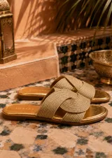Sandalias planas Zingara de color dorado, con capellada de tiras cruzadas en tejido trenzado y plantilla metalizada.
