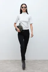 Pantalón slim fit color negro, con cierre de botón y cremallera, y bolsillos traseros.