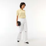 Remera de punto calado color amarillo, con cuello polo, manga corta y cierre frontal parcial con botones.