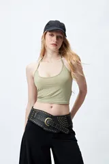 Top corto color verde oliva, estilo halter con tiras finas que se anudan en la nuca. Presenta un escote redondeado y un calce ajustado al cuerpo.