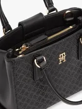 Cartera tote negra de poliuretano con acabado texturizado, motivo integral del monograma TH en bajo relieve, insignia metálica dorada en el frente, dos asas superiores y correa cruzada extraíble.