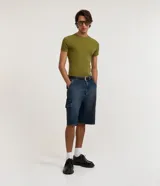 Bermuda baggy cargo para hombre confeccionada en jean, con bolsillos laterales utilitarios, trabillas en la cintura y cierre frontal tradicional.