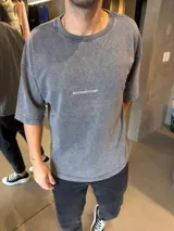 Remera de algodón de alto gramaje con efecto de lavado ácido, cuello redondo y mangas cortas. Presenta un diseño minimalista con el logo de la marca estampado en el centro del pecho.