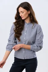 Camisa de manga larga con diseño de rayas verticales en azul y blanco, cuello mao y cierre frontal con botones.