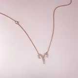 Collar dorado rosa con cadena fina y dije con el signo zodiacal aries, con incrustaciones de circonitas.