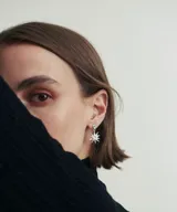 Aros colgantes plateados con forma de estrella de 17mm y un pequeño cristal azul en la parte superior.