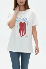 Remera de algodón color beige con estampado frontal de un corazón rosado que contiene un moño. Tiene cuello redondo y mangas cortas.