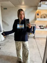 Sweater azul marino de tejido grueso, corte oversize y hombros caídos, con un bordado frontal que representa la bandera de Argentina.