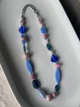 Collar de cuentas de cerámica, vidrio y cristal checo en tonos celestes, rosados y azules, con cierre metálico y cadena de alargue.