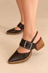Zapato de cuero vacuno color marrón con textura croco, diseño en punta, taco ancho de madera y tira en el empeine con hebilla metálica.