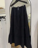 Falda larga negra de corte amplio con paneles escalonados.