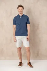 Chomba azul de piqué de algodón con cuello polo, tapeta de dos botones con diseño estampado en el interior y mangas cortas. Corte clásico.