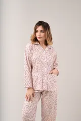 Pijama de dos piezas color rosa con estampado floral, ribete blanco, camisa abotonada de manga larga y pantalón largo.