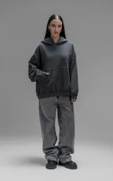 Hoodie oversize de algodón con efecto desgastado, costuras expuestas y roturas decorativas. Presenta capucha, bolsillo frontal tipo canguro y terminaciones deshilachadas.