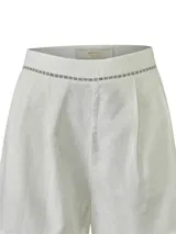 Short de lino orgánico color beige, de tiro medio y calce holgado, con detalles de aberturas bordadas en la cintura y en los dobladillos. Cuenta con bolsillos laterales y pinzas frontales.