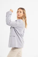 Blazer verde esmeralda de corte clásico con solapas y cierre con botones.