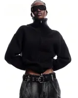 Campera de punto acanalado color negro, con cuello alto y cierre frontal doble. Presenta mangas largas y un diseño ajustado al cuerpo.