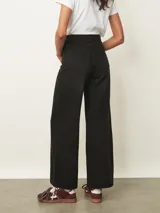 Jean de corte wide leg en color negro, con cintura alta ajustable mediante lazo y costuras verticales decorativas en el frente.