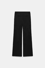 Pantalón negro de tiro bajo, corte recto con trabillas en la cintura y raya planchada al frente. Cuenta con bolsillos laterales y falsos bolsillos de vivo en la espalda. Cierre frontal con cremallera, botón interior y ganchos metálicos.