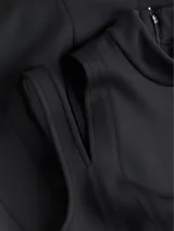 Vestido midi negro de punto técnico con corte entallado, cuello perkins, cremallera trasera, sin mangas, recortes en forma de media luna en los hombros, detalles de costuras verticales en la parte frontal y posterior, y hendidura en la espalda.