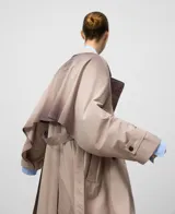 Gabardina cruzada color topo (gris claro/beige) con efecto envejecido, corte recto y doble botonadura. Presenta solapa doble en el lado derecho, manga larga con trabilla en el puño, y cinturón del mismo tejido.