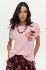 Remera de algodón color rosado, de manga corta, con cuello redondo y detalle de estampa y bordado frontal con diseño de una flor y una higuera.