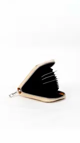 Tarjetero de diseño compacto en color tostado, con cierre perimetral metálico y visor frontal transparente para identificación o tarjetas.