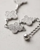 Cinto de cadena plateada con dijes en forma de trébol de cuatro hojas cubiertos de strass, ajustable.