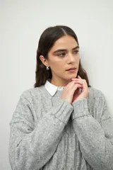 Sweater de punto gris con diseño tramado, cuello redondo y mangas largas con puños acanalados.