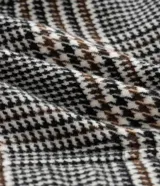 Campera tipo bomber de polivelour con estampado de cuadros, cuello inglés, cierre frontal, mangas largas y bolsillos funcionales.