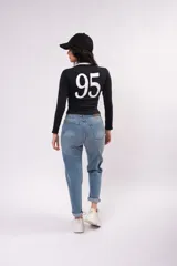 Remera de manga larga ajustada al cuerpo, color negro con cuello redondo blanco y franjas blancas laterales en las mangas. Presenta un estampado frontal con la inscripción 'Los Angeles' y una estrella pequeña.