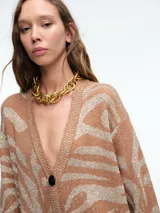 Cardigan de punto con escote en V y cierre frontal de botones. Presenta un diseño estampado de animal print con acabado brillante, mangas largas y corte holgado.