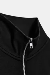 Sudadera crop entallada de color negro, con cuello alto, manga larga y cierre frontal de cremallera metálica. Presenta un diseño corto con bajo asimétrico.