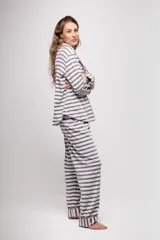 Pijama de tela tipo velvet a rayas horizontales grises y blancas, con vivos en color rojo. Incluye camisa de manga larga con botones frontales y bolsillo en el pecho, y pantalón recto con elástico en la cintura.