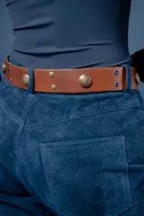 Cinto de cuero marrón gastado con detalles de tachas metálicas grandes, tachuelas pequeñas y apliques de piedras azules.