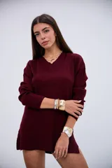 Sweater de punto acanalado en color bordó, con cuello en V y mangas largas. Presenta un diseño de corte recto con aberturas laterales en el ruedo.