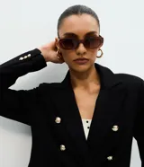 Blazer estructurado de corte cruzado en tejido de Punto Roma, con cuello de solapa, bolsillos con solapa, manga larga y botones metálicos dorados.