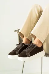 Zapatillas urbanas de cuero, color marrón oscuro, con paneles de gamuza y cuero liso, cordones al tono y suela de plataforma blanca.